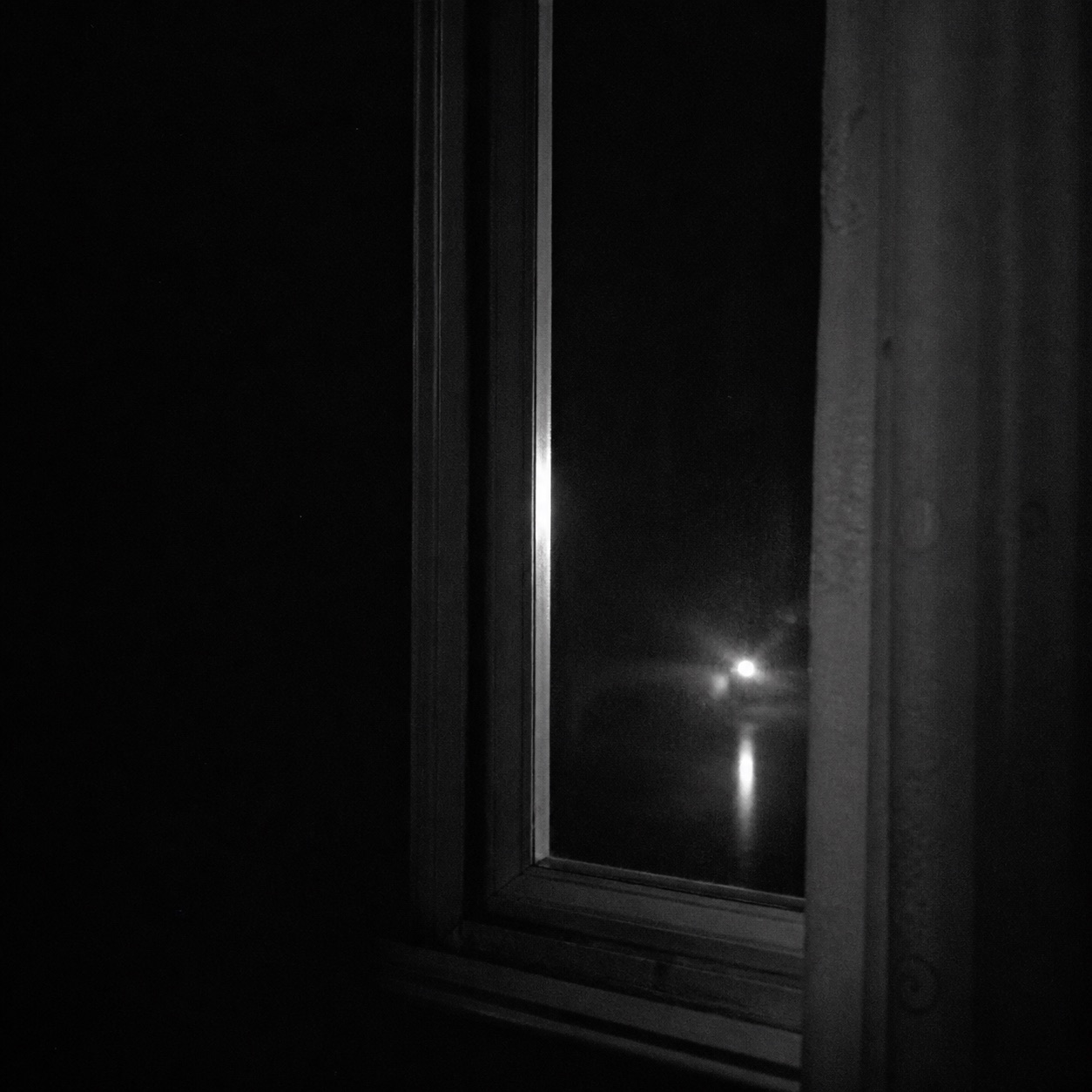 A dark window with a reflected light.